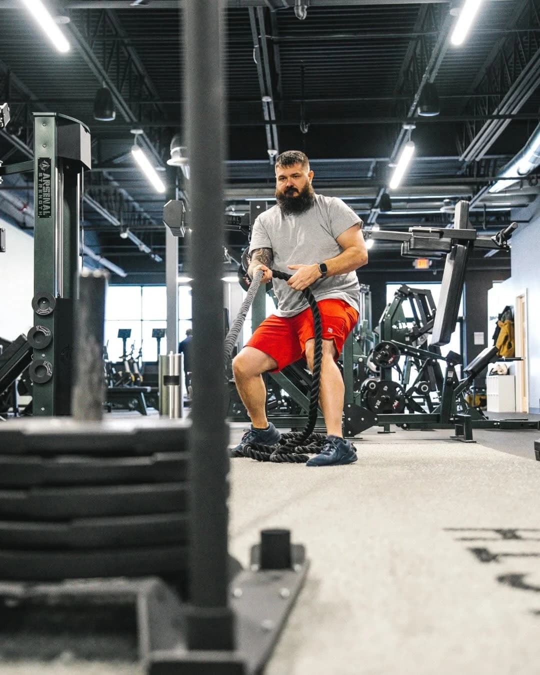 Ryan Davis working battle ropes on the gym floor at Summit Strength